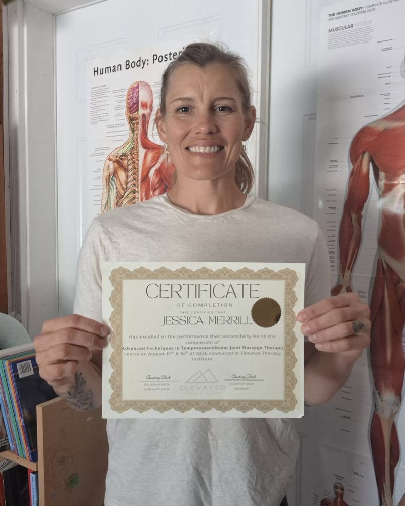 Jess holding her TMJ massage certificate of completion from Elevated Therapy Institute